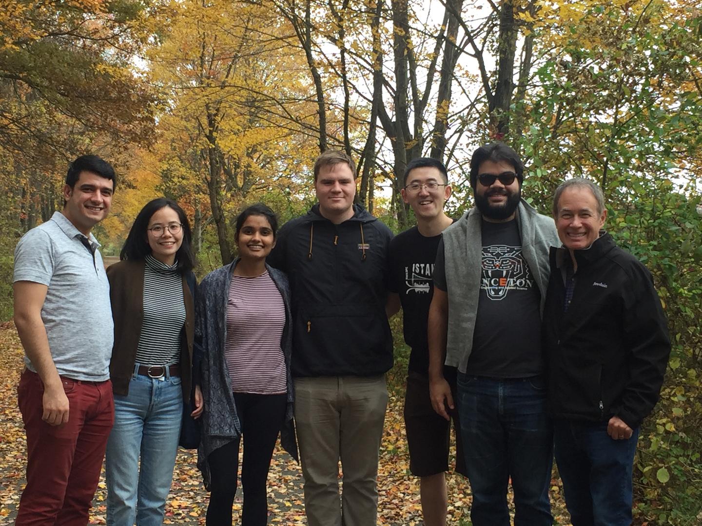 Group photo under trees with leaves changing color for the season