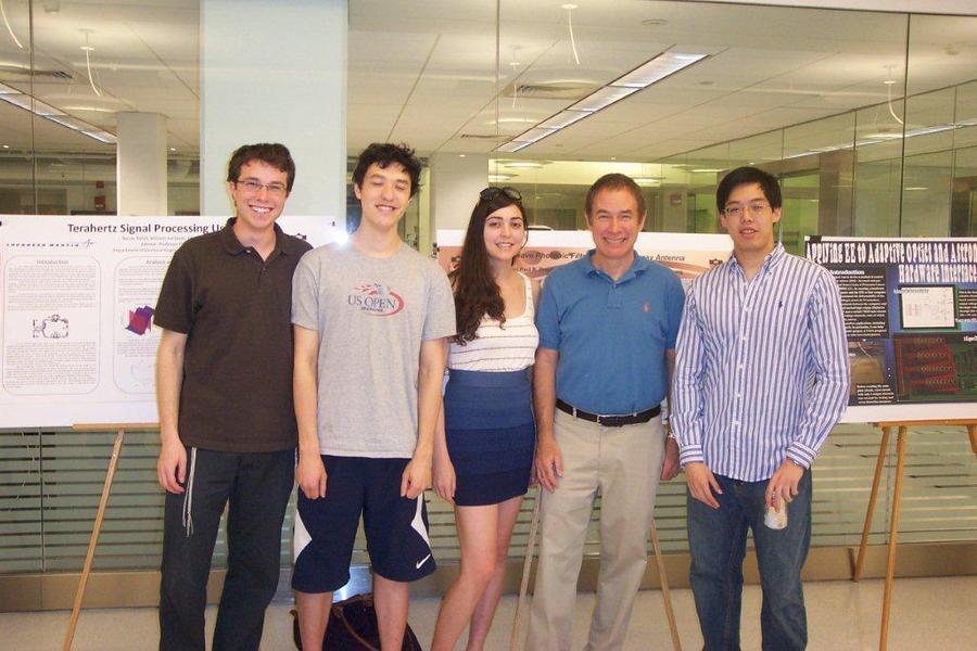 students standing in front of project presentations